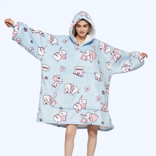 A woman modeling a light blue hoodie blanket with a elephant print, featuring oversized sleeves and a front pocket.