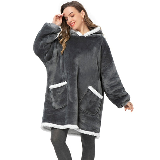 Person in cozy grey sherpa blanket hoodie with two pockets.