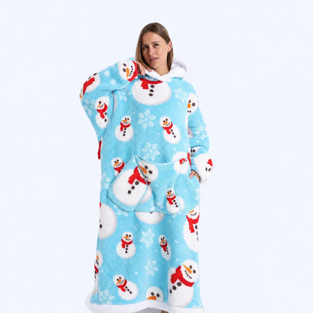 A woman wearing a light blue hoodie blanket  covered in a white snowman and snowflake pattern, with red scarves and small snowman faces.
