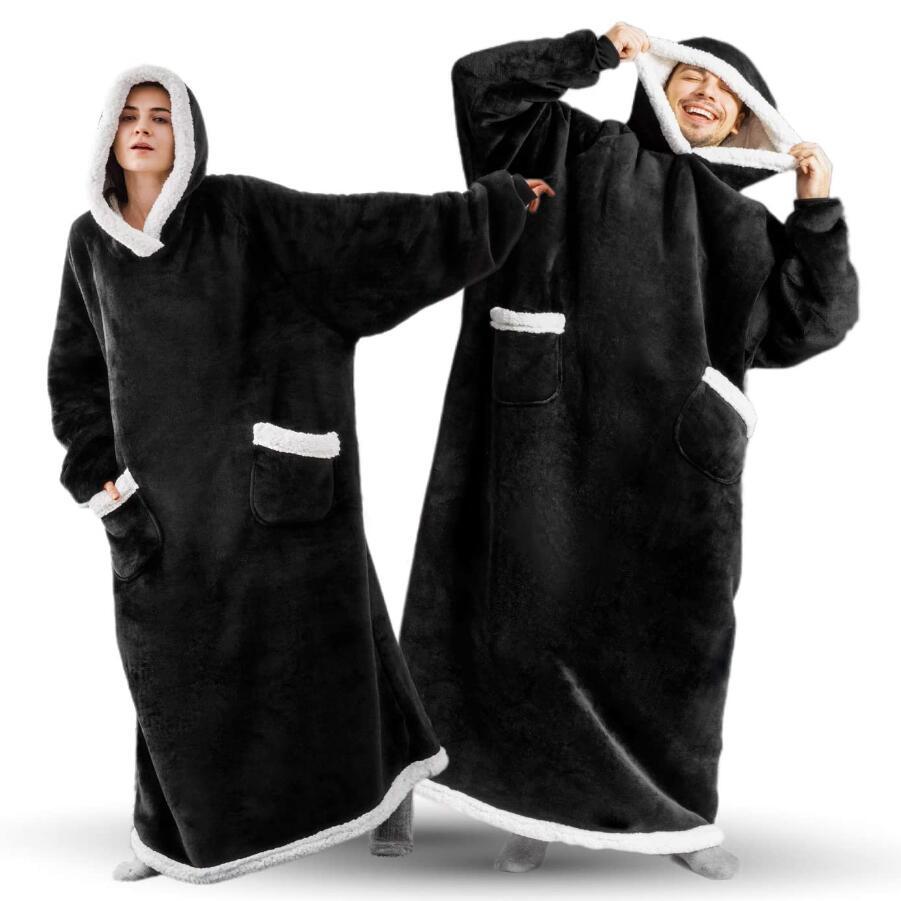 Woman and man wearing black extra long blanket hoodies that cover from head to toe. 