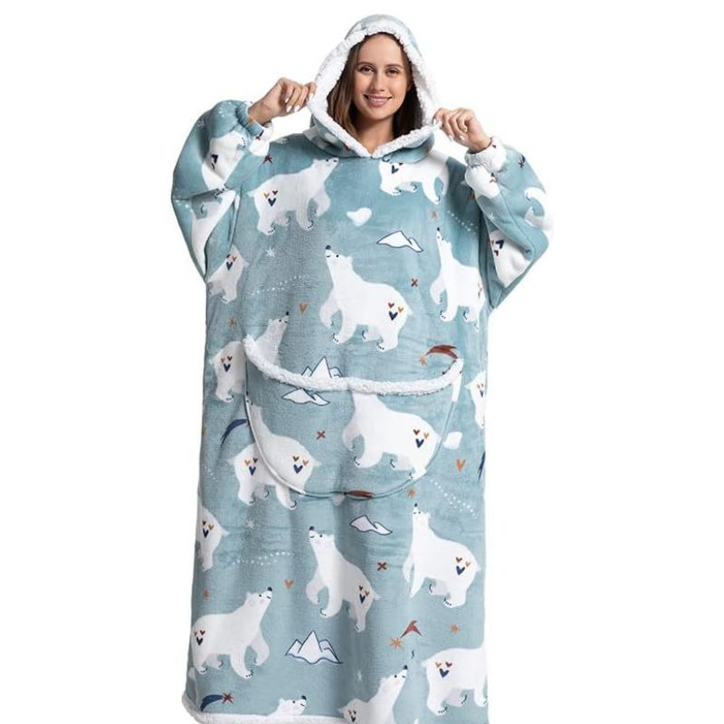 Smiling woman wearing a blue long snuggle hoodie with polar bear pattern. 