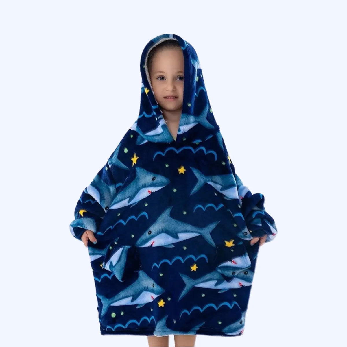 A young child wearing a hoodie blanket with a shark and ocean pattern, shown against a plain light gray background.