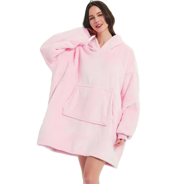 Person cozy in pink oversized blanket hoodie. 