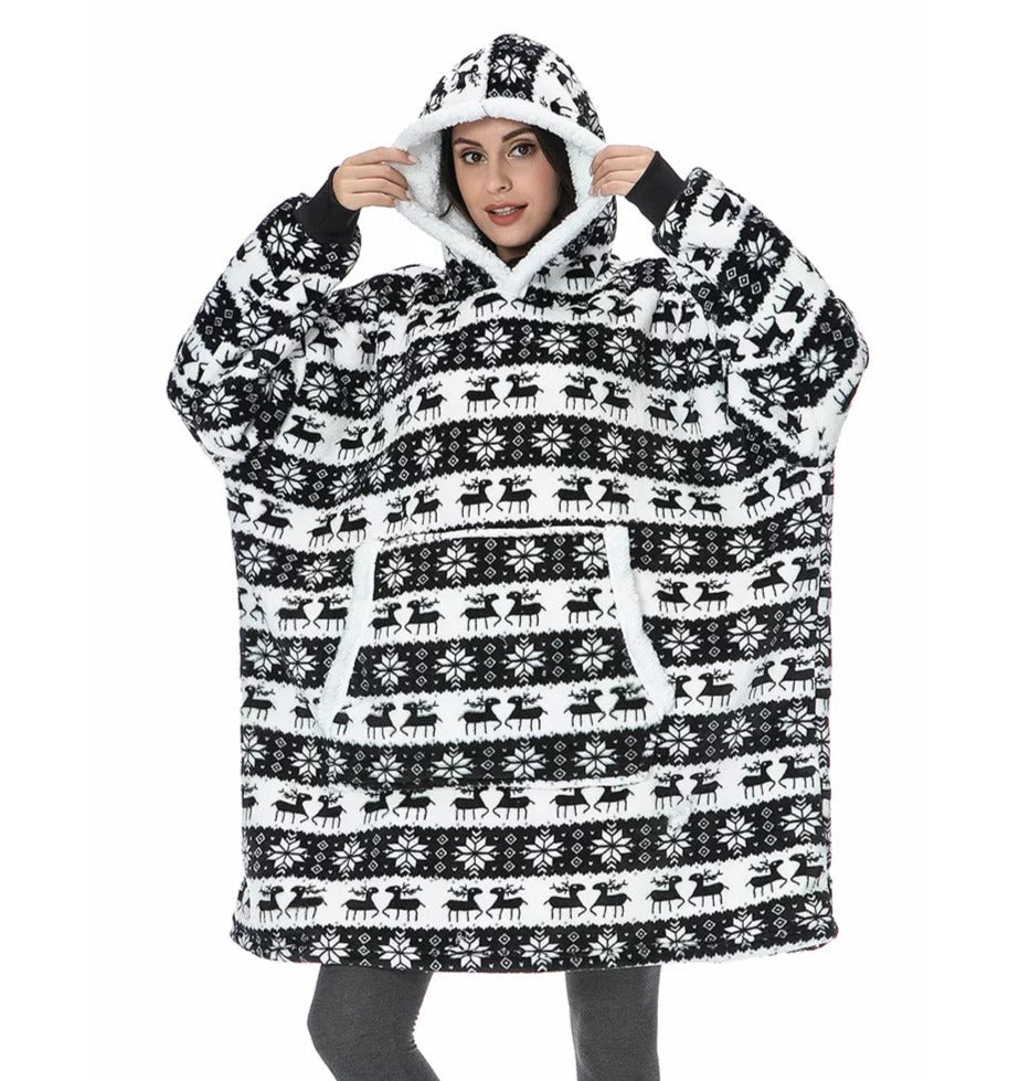 Model wearing a black, Christmas themed oversized blanket hoodie with reindeer pattern. 
