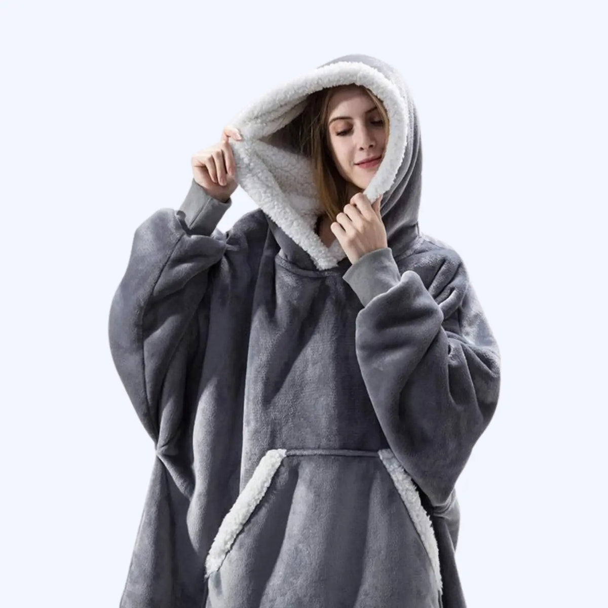 Woman wearing a grey hoodie blanket with sherpa-lined hood and pocket. 
