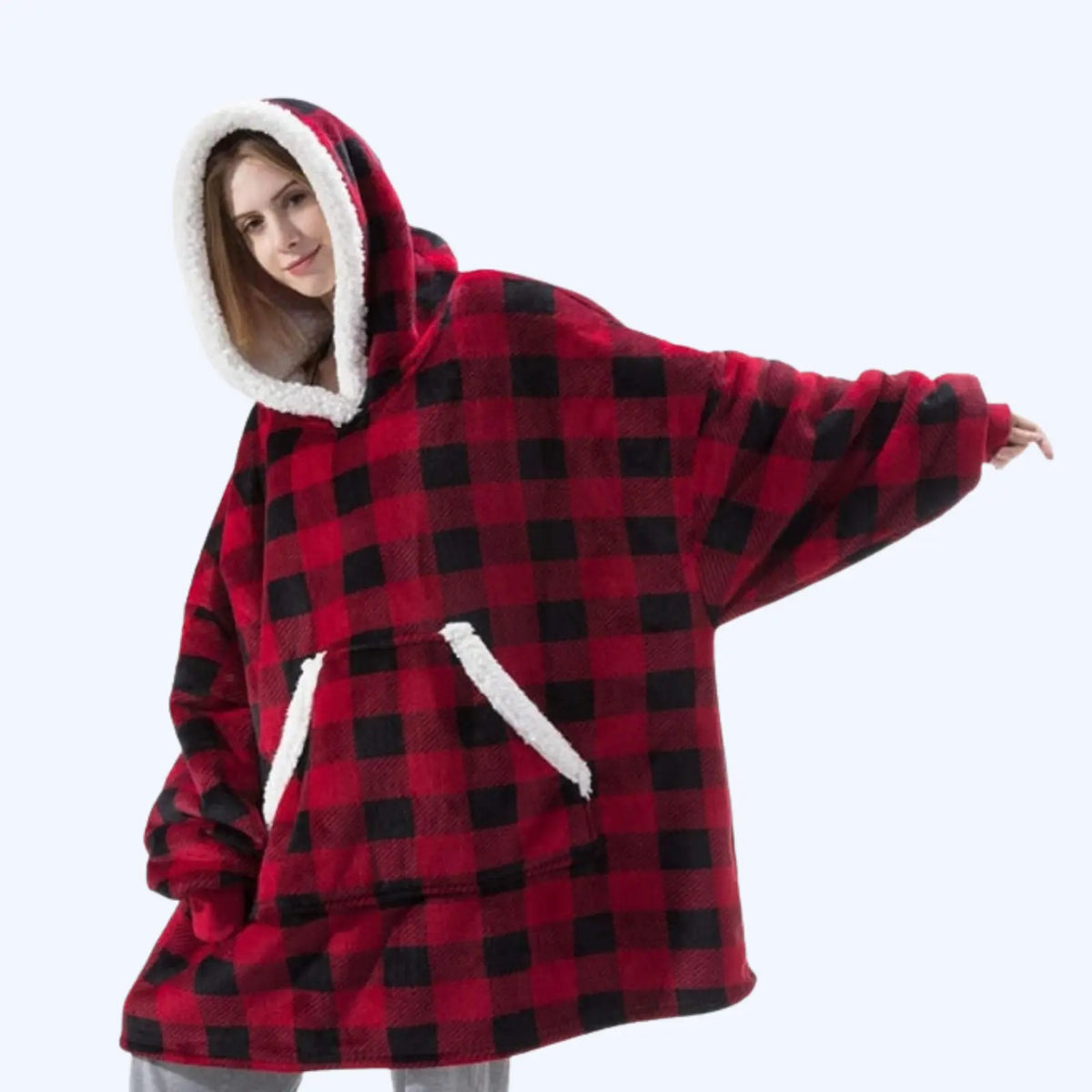 Woman wearing a black and red hoodie blanket with sherpa-lined hood and pocket. 