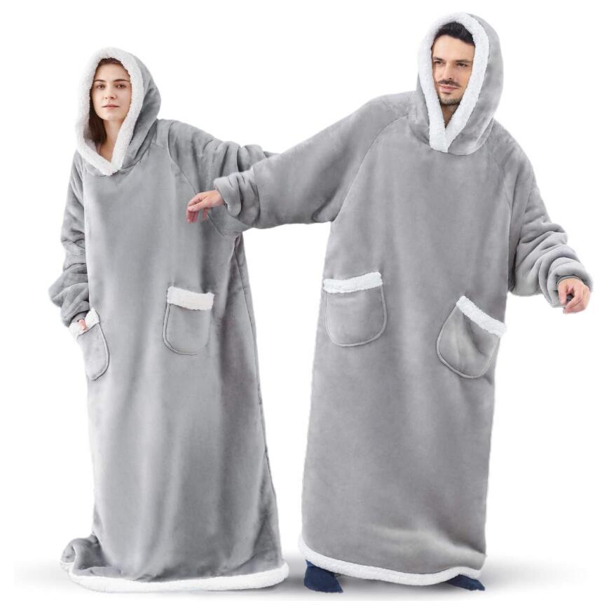 Woman and man wearing grey extra long blanket hoodies that cover from head to toe. 