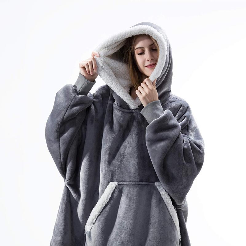 Woman wearing grey oversized sherpa blanket hoodie. 