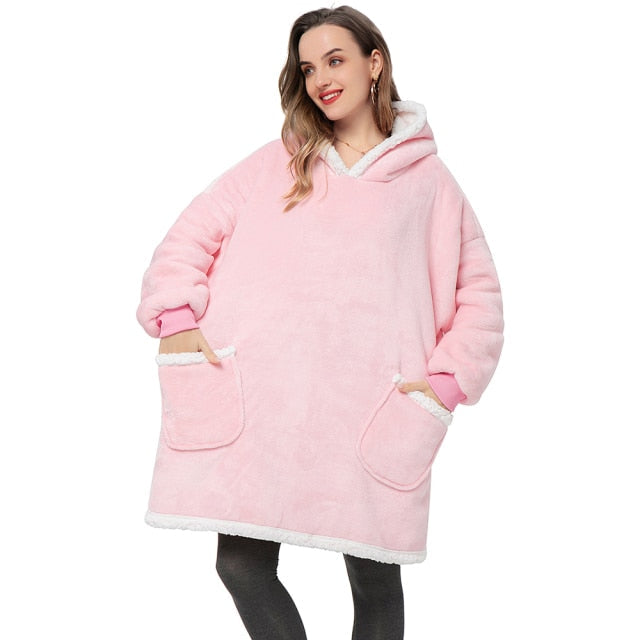 Person in cozy pink sherpa blanket hoodie with two pockets. 